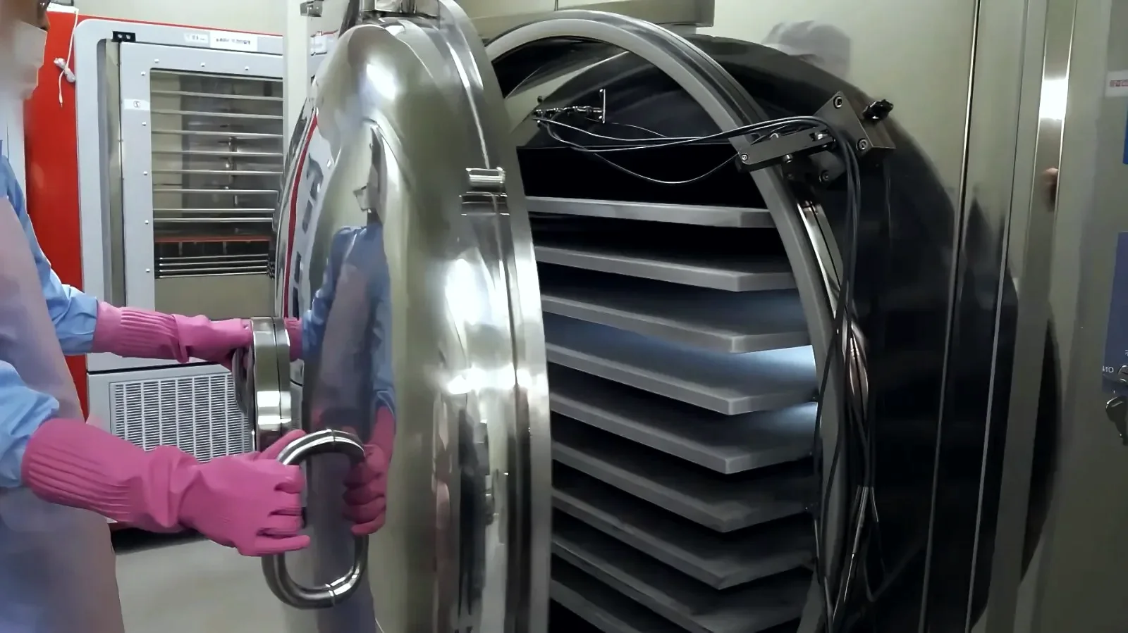 Operator at a compact freeze dryer in a clean room